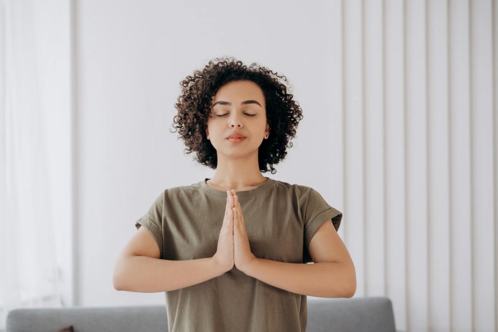 A person meditating in a minimalist, eco-friendly space