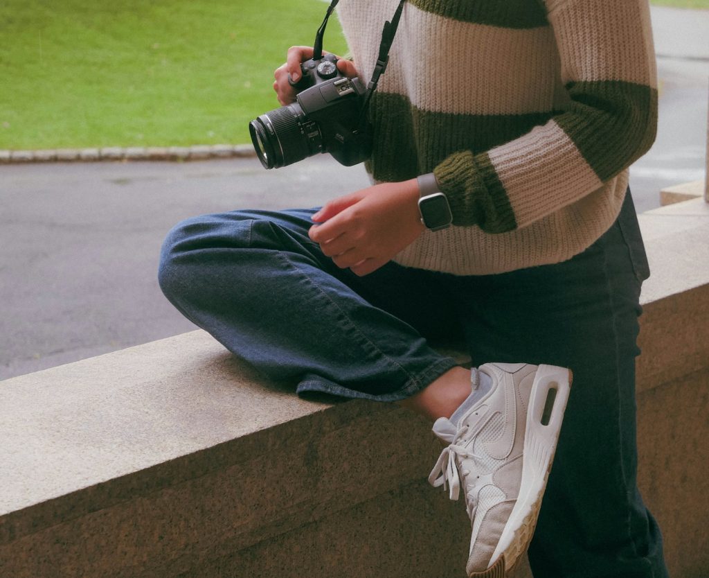 a person sitting on a ledge with a camera